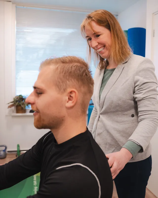 Leonie van Happy Life lacht met een cliënt tijdens een behandeling in de praktijk in Zeist