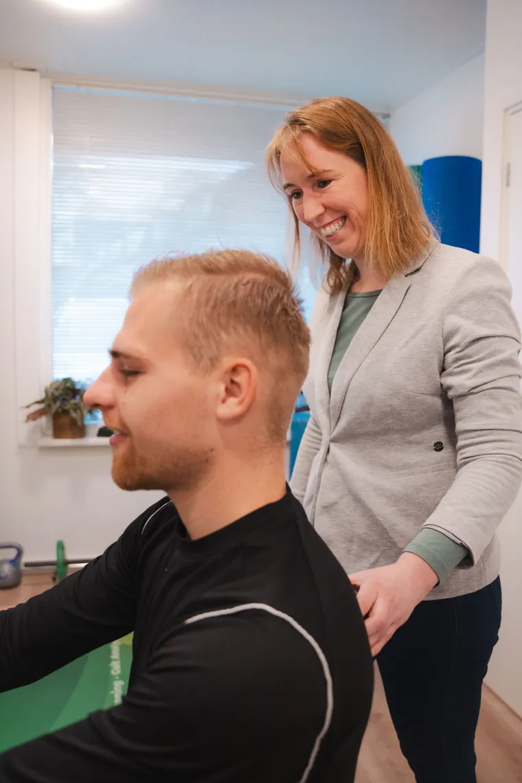Leonie van Happy Life lacht met een cliënt tijdens een behandeling in de praktijk in Zeist